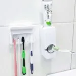 Toothpaste dispenser and brush holder